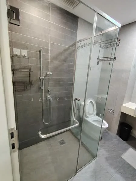 Bathroom features: glass shower enclosure, rain shower head, handheld shower, chrome wall-mounted faucet, toilet, grey tiled walls, grey tiled flooring, wall-mounted towel rack, built-in shelf for toiletries, vanity with countertop, black waste bin; style: modern.