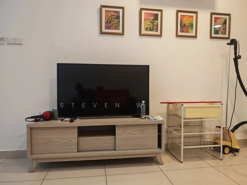Living features: flat-screen TV on wooden TV console, light wood TV console with storage compartments, white painted walls, ceramic tile flooring, framed artwork on walls, decorative wall art, water bottle on console, remote control on console, small cart with red top and wire storage, vacuum cleaner, floor lamp; style: modern.