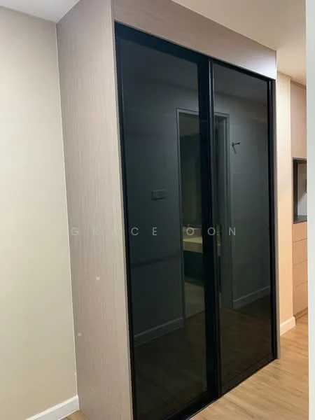 Room features: built-in wardrobe with sliding black glass doors, light wood paneling, neutral wall color, laminate flooring; style: modern.