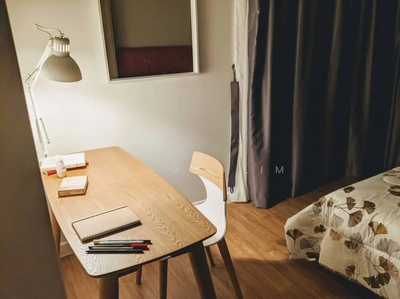 Room features: wooden desk, white chair, table lamp, notebook, pens, bed with floral bedding, curtains, wooden flooring, framed artwork on wall; style: modern.