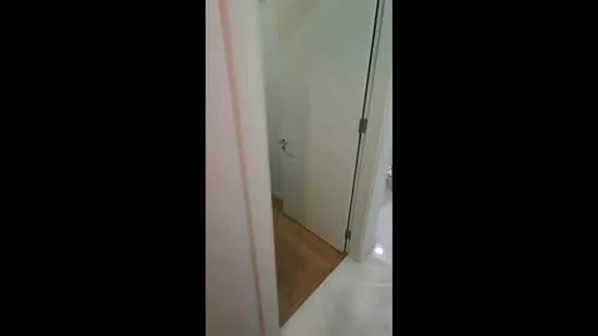 Room features: white painted walls, light wood flooring, door with modern handle, tile flooring visible, neutral color scheme; style: modern.