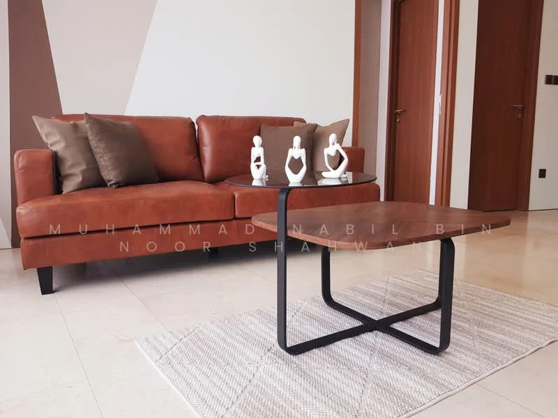 Living features: brown leather sofa, decorative cushions in neutral tones, modern coffee table with a curved top, black metal base for coffee table, area rug with a geometric pattern, decorative figurines on coffee table, light-colored marble flooring, white painted walls with accent colors; style: modern.