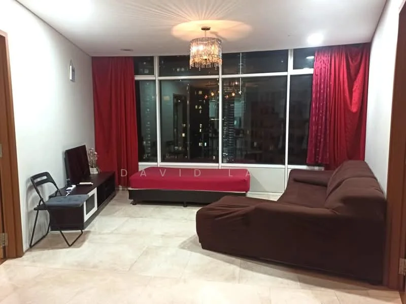 Living features: brown fabric L-shape sectional sofa, white TV console, wall-mounted TV, chandelier with crystal accents, floor-to-ceiling windows, red curtains, cream marble tile flooring, decorative wall art, coffee table with red cover, open space layout; style: modern; view: city.