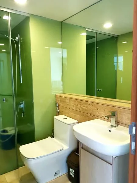 Bathroom features: glass shower enclosure, chrome shower head, single-sink vanity with wood cabinet, chrome basin mixer, framed mirror, one-piece toilet, green glass walls, tile flooring, wood accent wall, recessed downlights; style: modern.