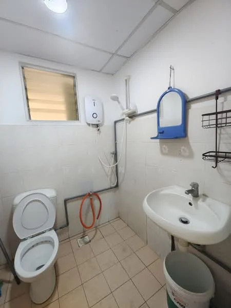 Bathroom features: white tiled walls, cream tiled flooring, one-piece toilet, sink with chrome faucet, shower with handheld showerhead, water heater, wall-mounted mirror, wire storage rack, plastic bucket, shower curtain rod.