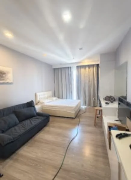 Room features: light grey painted walls, laminate flooring, recessed downlights, floor-to-ceiling windows, sheer curtains, queen-size bed, upholstered headboard, sofa in dark grey, wooden stool, TV console, wall-mounted TV; style: modern.