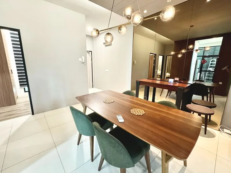 Dining features: wooden dining table, 4 green upholstered dining chairs, decorative coasters on table, pendant lighting with multiple bulbs, white tiled flooring, grey painted walls, mirror on wall, open layout to adjacent rooms; style: modern. Room features: doorway leading to other rooms, wooden paneling in adjacent room, light wood flooring visible in background.