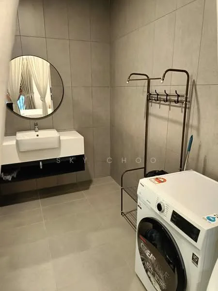Bathroom features: grey tiled walls, light grey tile flooring, round mirror, white sink with modern faucet, black vanity cabinet, clothes rack with hooks, front-load washing machine; style: modern.