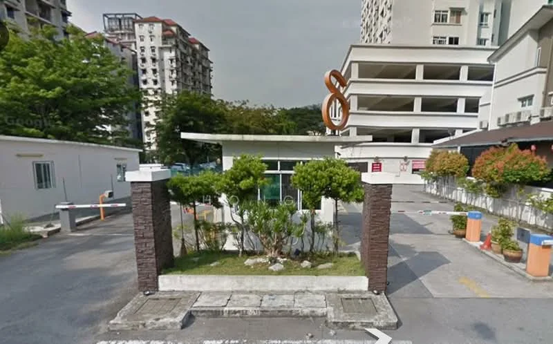 Exterior type: gated community entrance; features: guard house at entrance, landscaped greenery, paved driveway, number '8' sign, surrounding residential buildings, parking area, security boom gate, perimeter fence; style: modern.