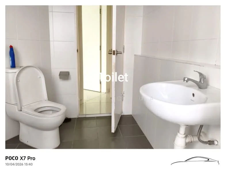 Bathroom features: white tiled walls, grey tile flooring, one-piece toilet, wall-mounted sink, chrome basin mixer faucet, mirror above sink, door leading to another room.