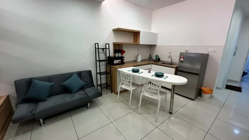 Kitchen features: grey fabric sofa, white dining table, two white dining chairs, stainless-steel fridge, built-in kitchen cabinets, white tiled backsplash, ceramic tile flooring, kitchen sink, kettle, microwave, coffee machine, wall-mounted shelving unit; style: modern.