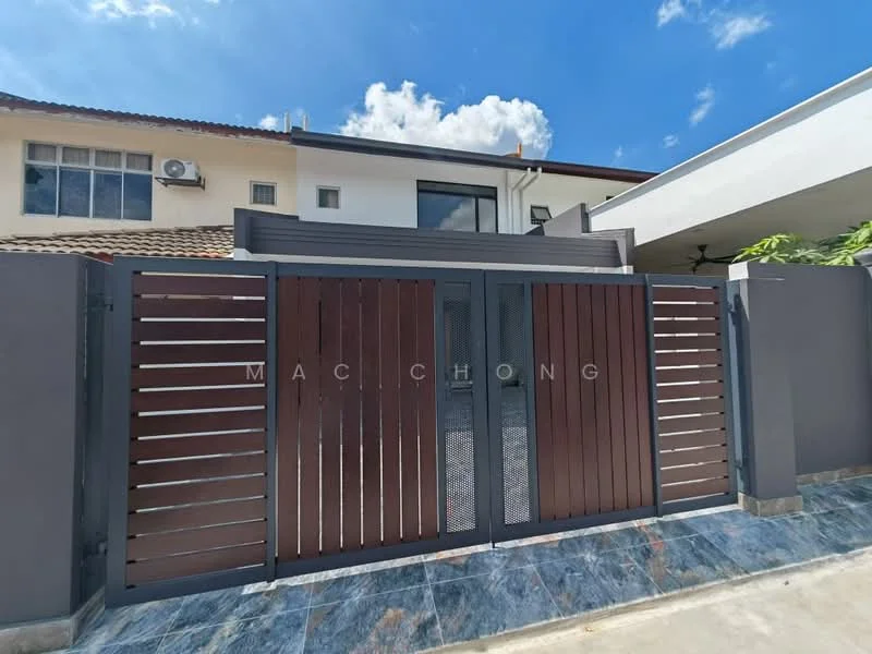 Exterior type: detached bungalow; features: wooden slatted gate, metal frame around gate, grey exterior walls, stone-paved driveway, landscaped garden area, single-storey structure, large windows visible, roof overhang, clear blue sky; style: modern.