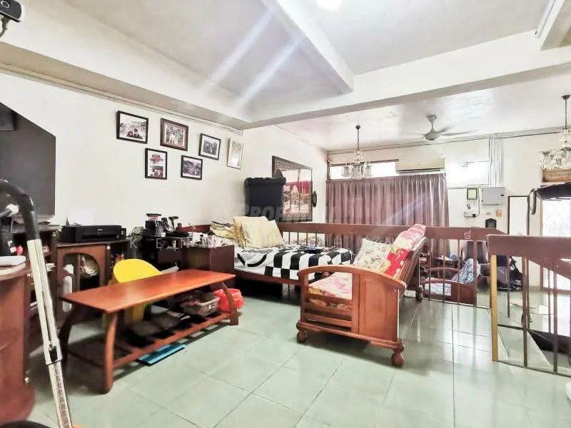 Living features: green ceramic tile flooring, white painted walls, exposed beams on ceiling, 5-blade ceiling fan, sofa with patterned upholstery, wooden coffee table, wooden armchair, framed photographs on walls, curtains, TV console, decorative cushions; style: traditional.