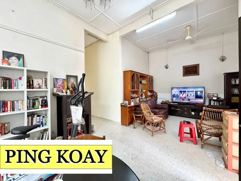 Living features: white painted walls, exposed ceiling beams, ceiling fan, wall-mounted TV, 3-seater fabric sofa in dark brown, wooden coffee table, bookshelf with books, wooden display cabinet, woven chairs, tile flooring, decorative wall art, area rug; style: traditional.
