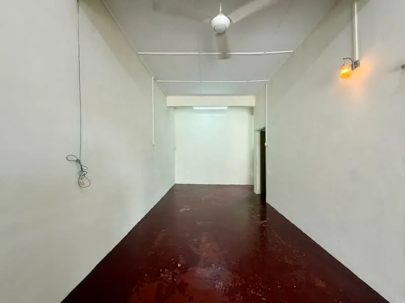 Room features: white painted walls, red concrete flooring, ceiling fan, fluorescent lighting, single door, exposed electrical wiring; style: minimalist.