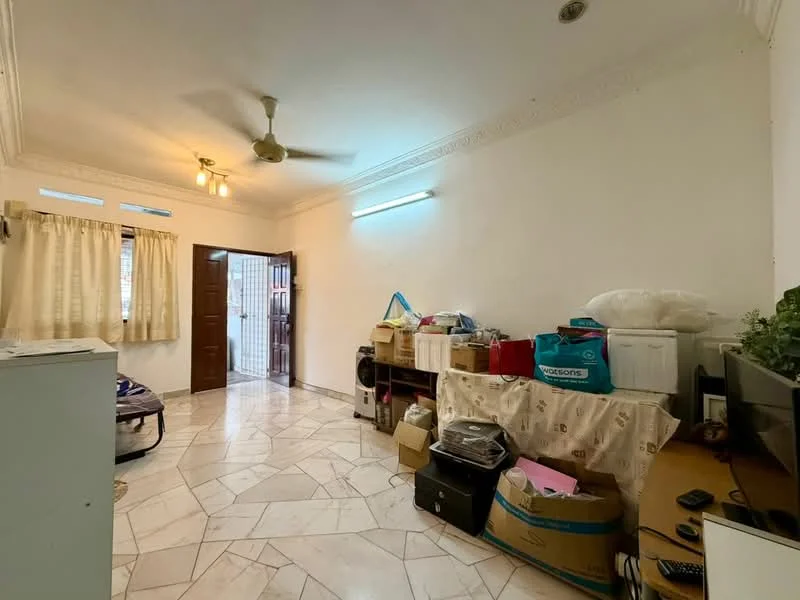 Room features: white painted walls, marble tile flooring, ceiling fan, window with sheer curtains, wooden door, light fixture, various boxes and storage items, desk with monitor.