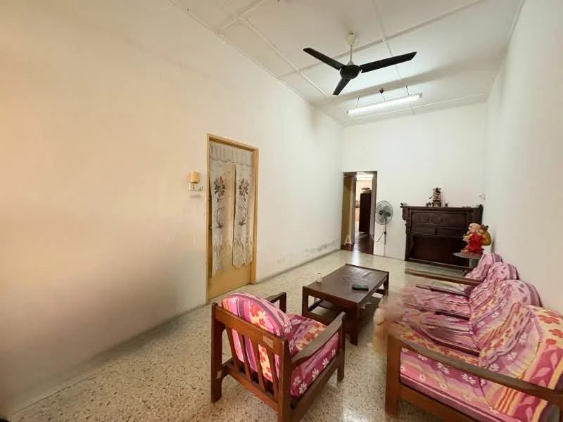 Living features: white painted walls, polished concrete flooring, 5-blade ceiling fan, wooden coffee table, 2-seater wooden sofa, 3-seater fabric sofa with floral pattern, decorative wall hanging, wooden cabinet, floor fan; style: traditional.