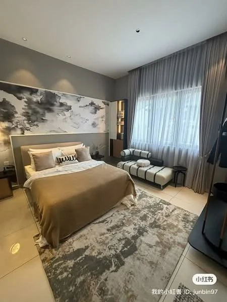 Bedroom features: king-size bed with beige bedding, upholstered headboard, decorative throw pillows, area rug with geometric pattern, floor-to-ceiling window with sheer curtains, wall-mounted artwork with abstract design, built-in wardrobe with sliding doors, accent chair with black and white pattern, nightstand with lamp, recessed ceiling lights; style: modern.