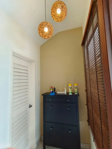 Laundry features: black chest of drawers, two decorative pendant lights, white walls, cream accent wall, window with wooden blinds, tile flooring; style: modern.