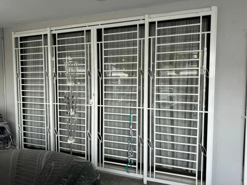 Room features: white security grilles, black window treatments, grey tiled flooring.