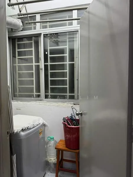 Laundry features: washing machine, window with metal grille, white walls, wooden stool, plastic basket, tile flooring.