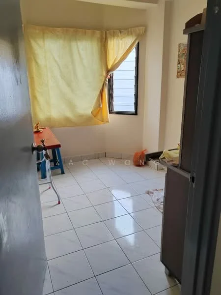 Room features: yellow sheer curtains, white tiled flooring, single window, light-colored walls, corner table, refrigerator, plastic chair, visible clutter on the floor.