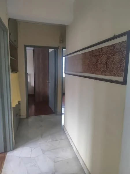 Hallway features: marble flooring, cream painted walls, framed artwork on wall, wooden door, open shelving, light from window, neutral color scheme, baseboard trim; style: modern.
