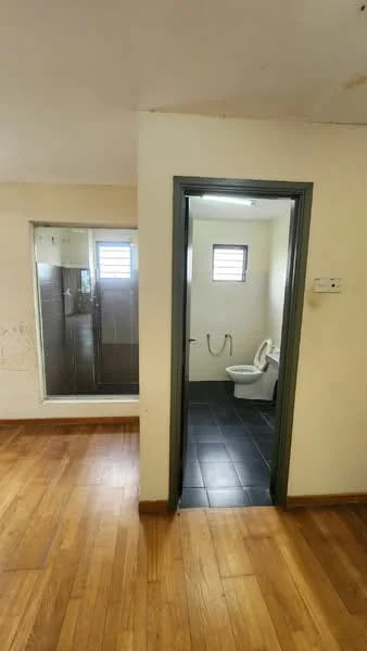 Bathroom features: walk-in shower with glass enclosure, chrome handheld shower, white toilet, grey tiled flooring, cream painted walls, window for natural light, grab bar, light fixture on ceiling; style: modern. Room features: wooden flooring, cream painted walls, doorway leading to bathroom, light fixture on ceiling.