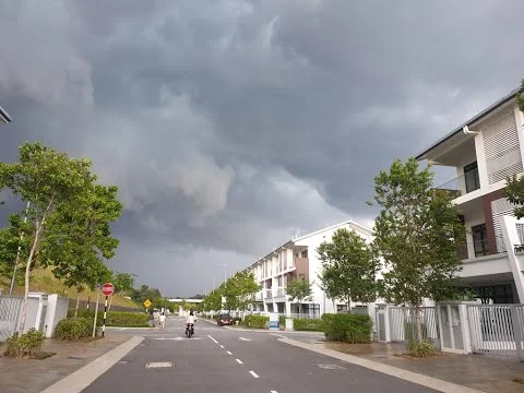 Exterior type: linked terrace house; features: white painted facade, cream painted facade, 2-storey buildings, manicured lawn, mature trees, paved walkway, street signage, stormy sky, road with lane markings, fencing around properties; style: modern.