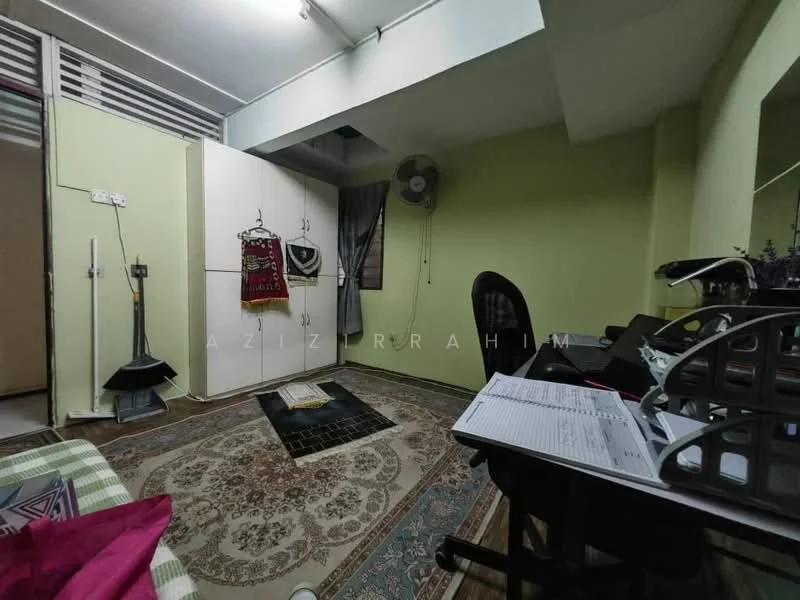 Room features: green painted walls, wall-mounted ceiling fan, area rug with geometric pattern, built-in wardrobe with sliding doors, desk with office chair, window with sheer curtains, decorative wall hanging, paperwork on desk.