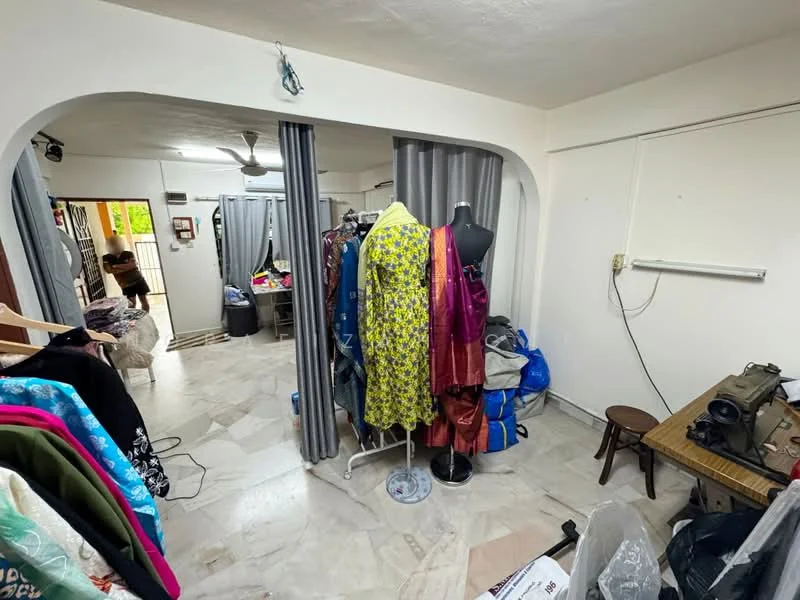 Room features: marble flooring, white painted walls, ceiling fan, clothing rack, mannequin, folding chair, curtains, various fabrics and garments.