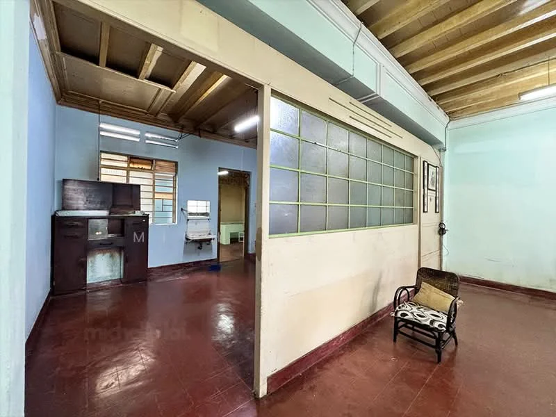 Room features: blue painted walls, red tile flooring, exposed wooden ceiling beams, partition wall with glass panels, wooden chair with cushion, kitchen area visible in background, window with grid design, light fixture on ceiling; style: traditional.