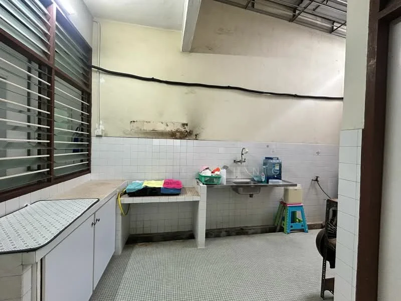 Kitchen features: white tiled walls, grey tiled flooring, single-bowl stainless-steel sink, chrome faucet, white cabinetry, countertop with space for appliances, window with horizontal slats, plastic stool, basket for storage, cleaning cloths in various colors.