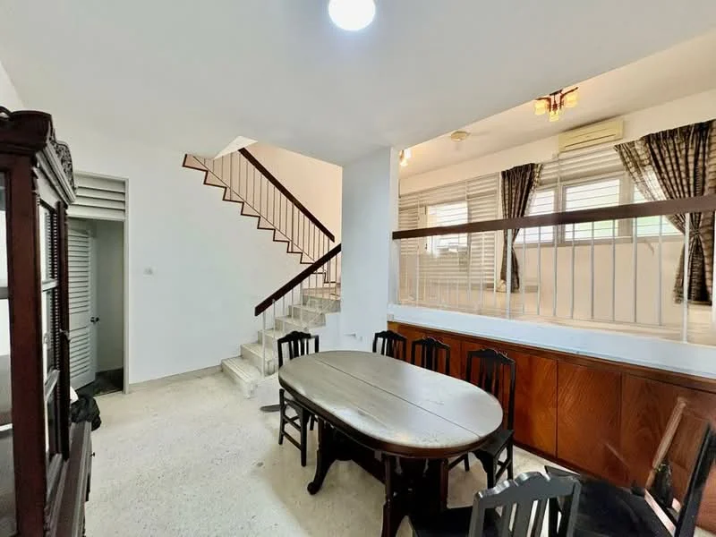 Dining features: round wooden dining table, 8 wooden dining chairs, white painted walls, exposed ceiling with lights, staircase leading to upper floor, window with sheer curtains, wood paneling on lower wall, tile flooring; style: modern. Room features: white painted walls, tile flooring, staircase.