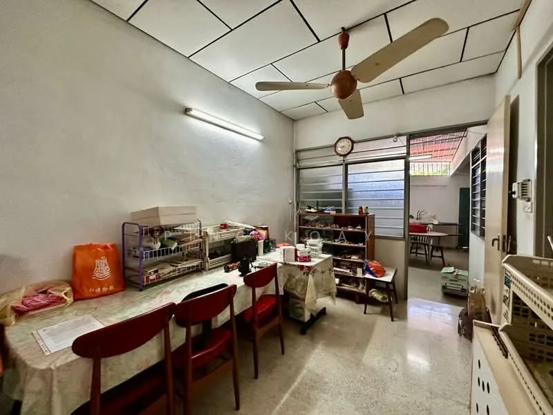 Dining features: table with 6 wooden chairs, ceiling fan, white painted walls, polished concrete flooring, large window with metal grille, wall clock, shelves with various items, light fixture, open layout to adjacent room. Room features: open doorway to adjacent room, additional shelves visible.