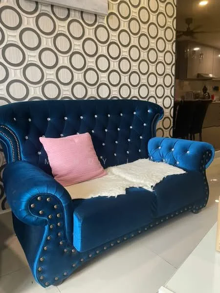 Living features: blue velvet tufted sofa, decorative nailhead trim, pink decorative pillow, white throw blanket, geometric patterned wallpaper, white tiled flooring, recessed lighting, open layout to kitchen area; style: modern.