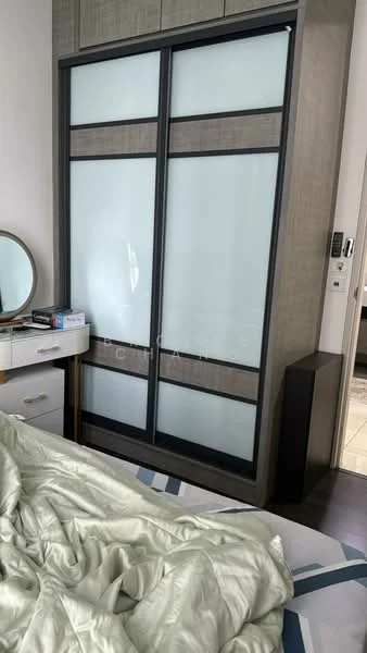Bedroom features: sliding wardrobe with frosted glass panels, wooden flooring, round mirror on dresser, white dresser with drawers, bed with rumpled bedding, decorative throw blanket, nightstand, wall-mounted light switch, visible electrical outlets; style: modern.