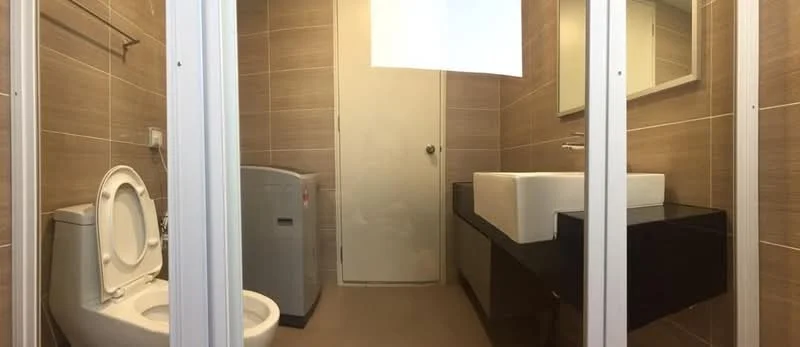 Bathroom features: one-piece toilet, single-sink vanity with rectangular basin, black cabinetry under sink, mirror above sink, grey washing machine, light brown tiled walls, light brown tiled flooring, door to bathroom, chrome faucet; style: modern.