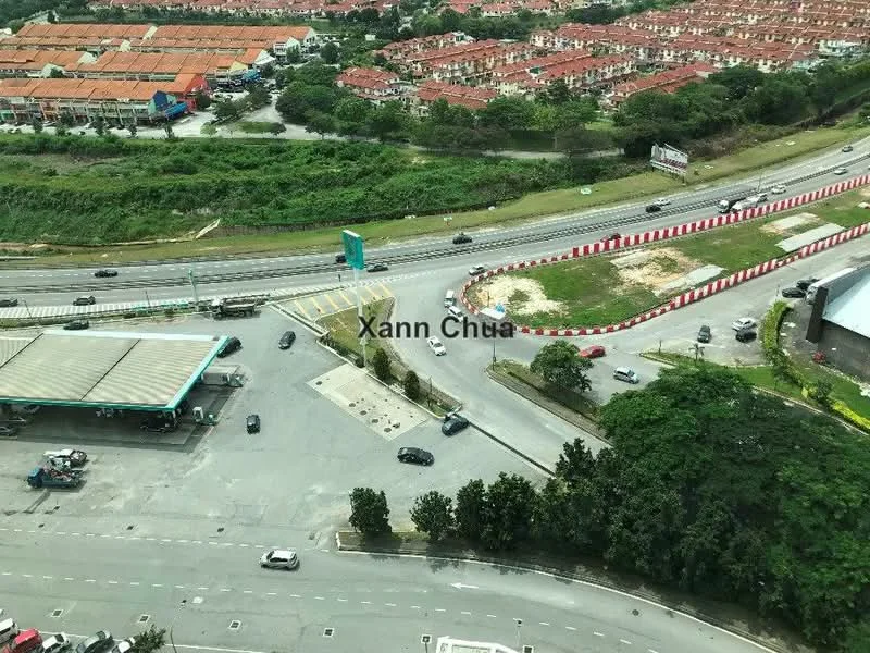Exterior features: view of road, surrounded by greenery, urban context, nearby residential area, gas station visible, multiple vehicles on road, striped road barriers.