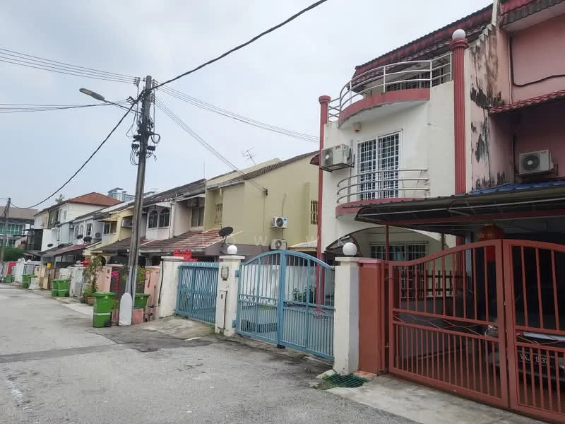 Exterior type: linked terrace house; features: two-storey linked terrace houses, painted facade in cream and yellow, red tiled roof, balconies on upper floors, metal gates in red and blue, visible air conditioning units, street view with utility poles, paved driveway, manicured front yards, surrounding residential area; style: modern.