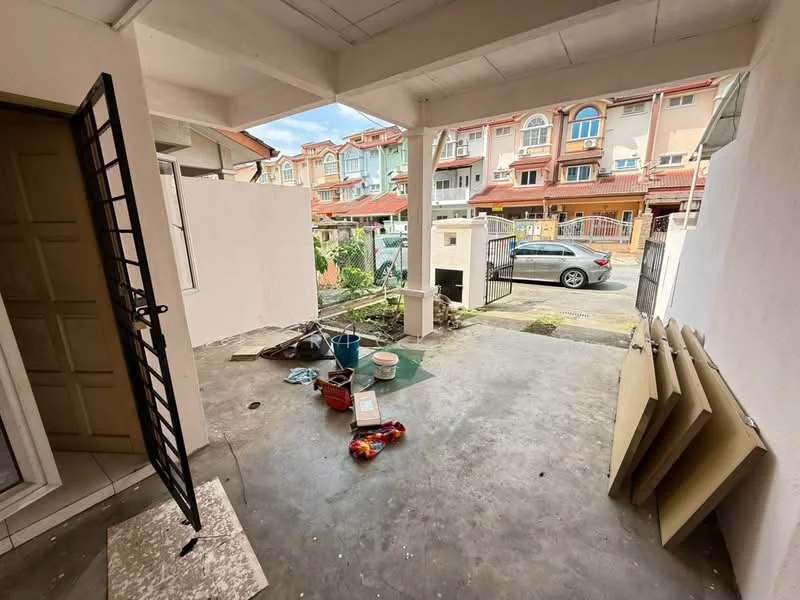 Room features: concrete flooring, white painted walls, open space, front porch area, metal gate, door leading to interior, visible outdoor area, scattered construction materials; view: street.