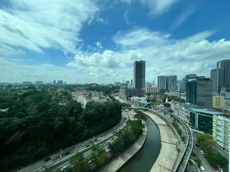 Exterior type: high-rise condominium; features: city skyline view, surrounded by greenery, river running through, urban landscape, multiple high-rise buildings, clear blue sky, clouds, roadway visible; style: modern.