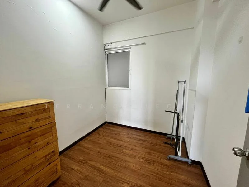 Room features: white painted walls, wooden flooring, single window with sheer curtains, ceiling fan, wooden chest of drawers, metal clothing rack.