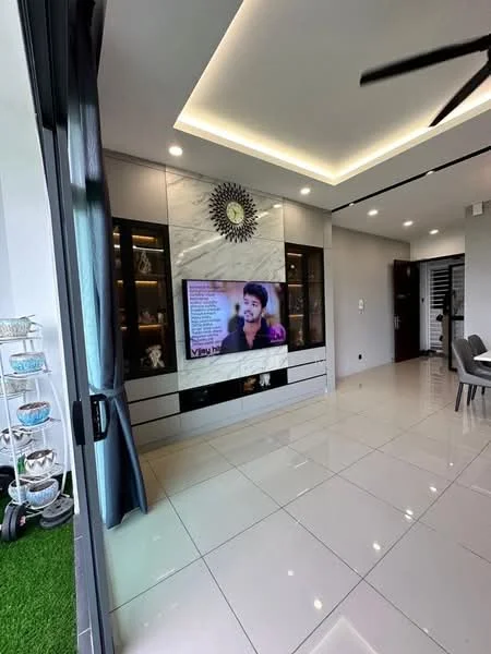 Living features: large flat-screen TV, white glossy media console, decorative wall with circular mirror, recessed ceiling lights, tray ceiling, grey curtains, ceramic tile flooring, ceiling fan, open layout, wall-mounted decor, greenery visible outside, dining area visible in background; style: modern; view: garden.