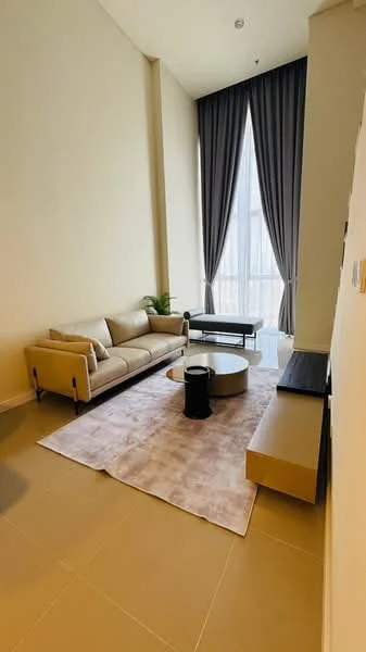 Living features: 3-seater fabric sofa in beige, coffee table, TV console, wall-mounted TV, area rug with geometric pattern, floor-to-ceiling windows, sheer curtains, light-colored walls, tile flooring, decorative plant; style: modern; view: city.