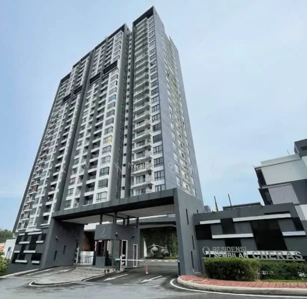 Exterior type: high-rise condominium; features: glass curtain wall, grey painted facade, recessed balconies, main entrance with canopy, landscaped entrance area, surrounded by greenery, multiple storeys, visible parking area; style: modern.