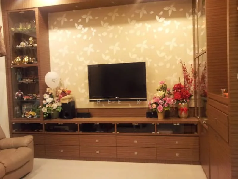 Living features: wall-mounted TV, wooden TV console, decorative wall with floral pattern, glass display cabinets, decorative vases, artificial flowers, cream-colored walls, light-colored flooring, recessed lighting, upholstered armchair; style: modern.