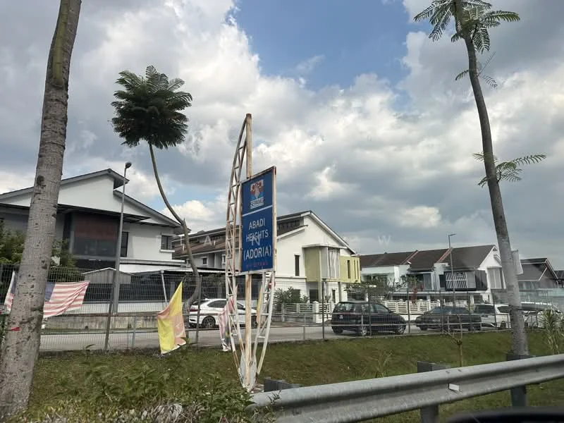 Exterior type: linked terrace house; features: white painted facade, projecting balconies, two-storey building, manicured lawn, palm trees, fenced perimeter, signboard at entrance, surrounded by greenery; style: modern.