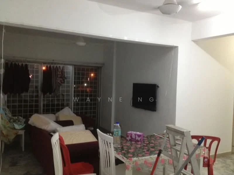 Living features: 3-seater fabric sofa in red, 2-seater fabric sofa in beige, coffee table, wall-mounted TV, ceiling fan, white painted walls, tile flooring, curtains on windows, dining table with floral tablecloth, ladder, decorative items on table.