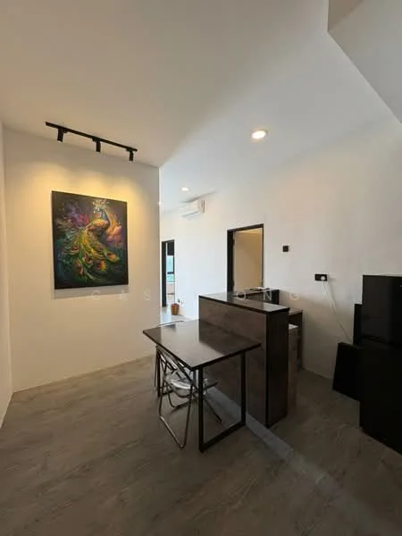Room features: white painted walls, grey laminate flooring, track lighting, wall-mounted air conditioning unit, black dining table, metal folding chairs, framed artwork on wall, black refrigerator, doorway leading to another room; style: modern.